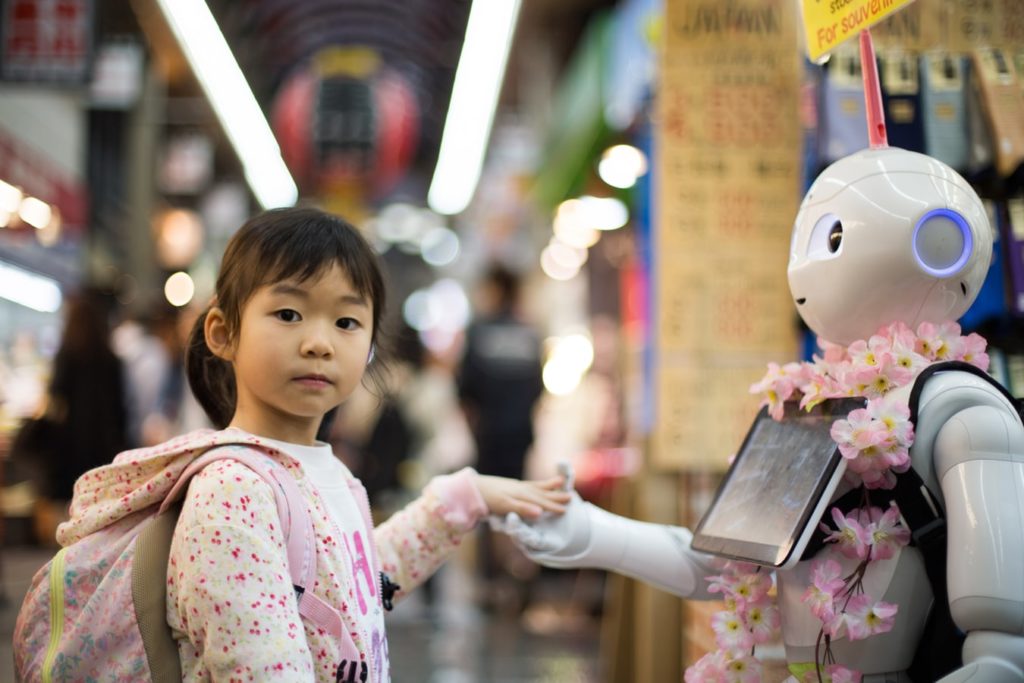 Girl holding the hand of a robot