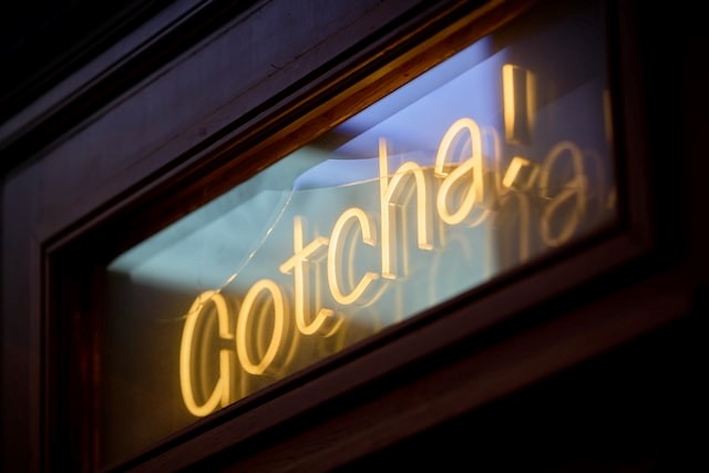 A light-up sign display the wording Gotcha! Using images to break up your website copy makes it more readable