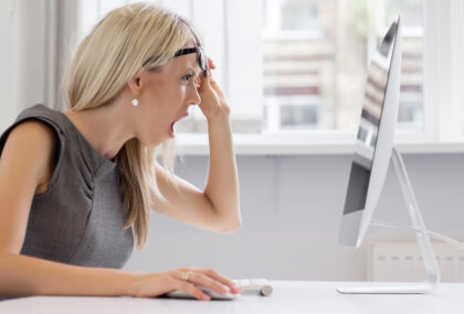 Woman looks at computer in disbelief and shock