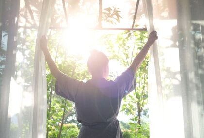 Woman opening curtains, letting in light